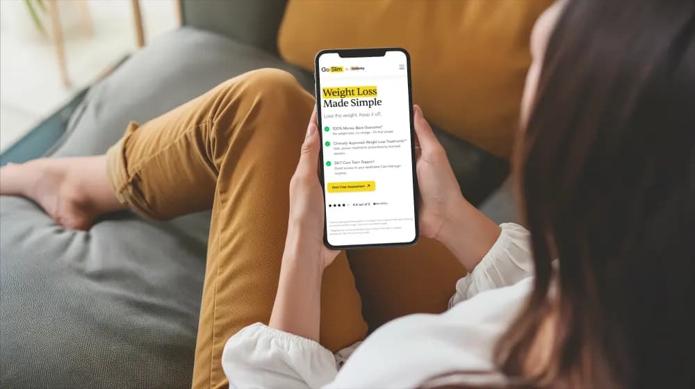 woman-sitting-on-couch-holding-cell-phone-modern-technology-and-goslim